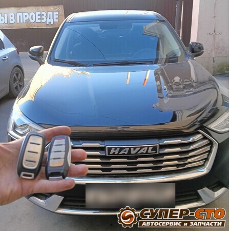 Штатный и новый смарт-ключ в руке на фоне Haval Jolion