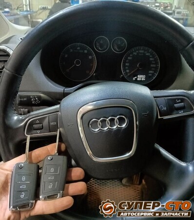 Два новых выкидных ключа на фоне руля Audi A3