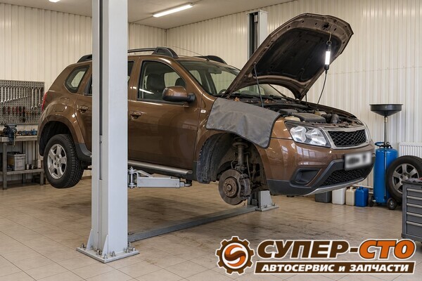 Renault Duster на подъёмнике: капот открыт, на крыле защитная накидка, правое переднее колесо снято