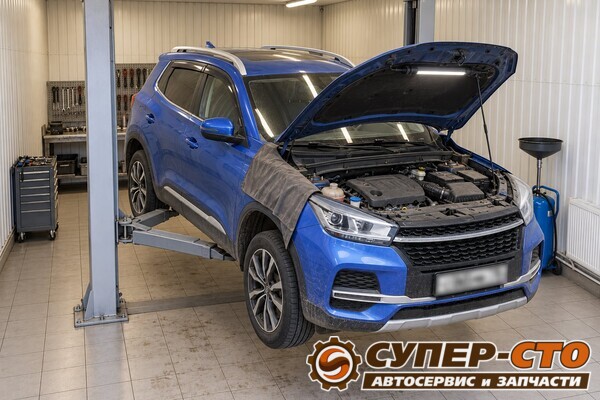 Синий Chery Tiggo 4 на подъёмнике в боксе, открыт капот